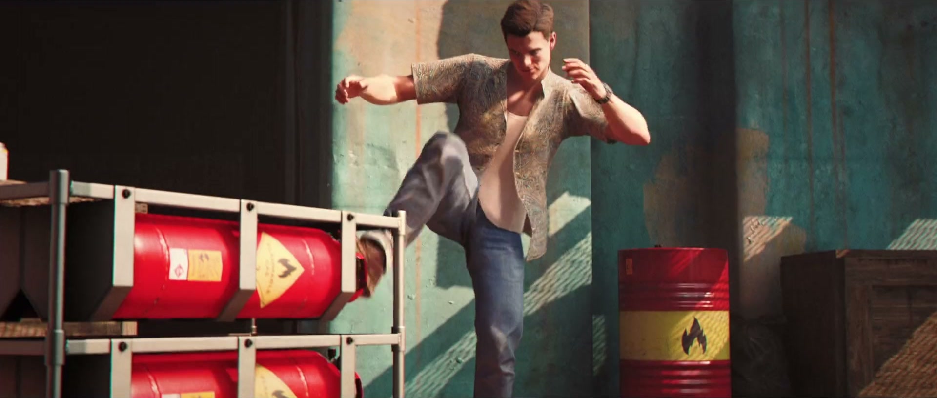 Official 007 First Light screenshot — Bond in a patterned shirt mid-kick beside a rack of red flammable fuel drums against a weathered teal concrete wall.