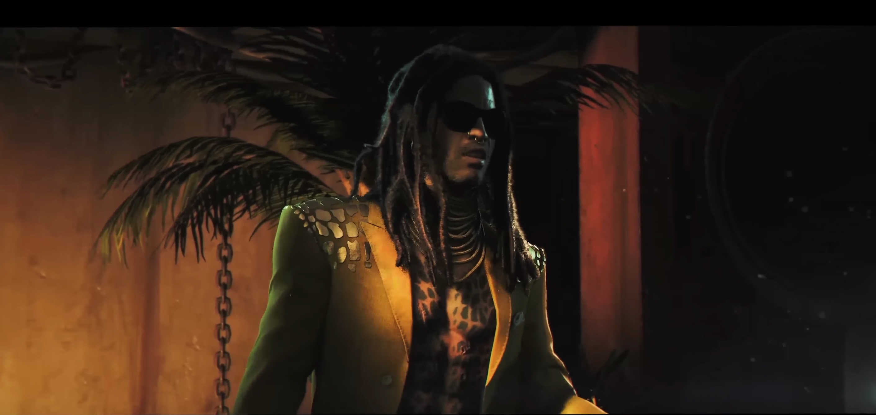 Official 007 First Light trailer frame — Bawma in a studded gold jacket over a leopard-print top, dreadlocks and dark sunglasses, lit warm against shadow with a palm frond behind him.
