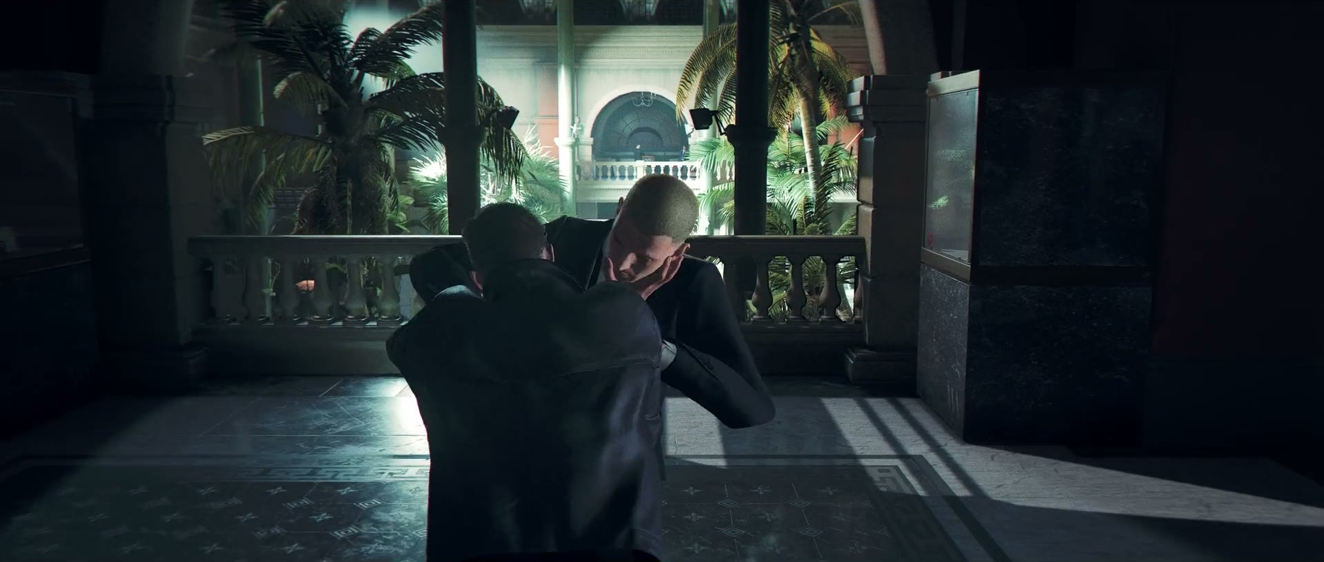 Official 007 First Light screenshot — James Bond takes aim from the shadows of a dim marble hall toward a brightly lit doorway.
