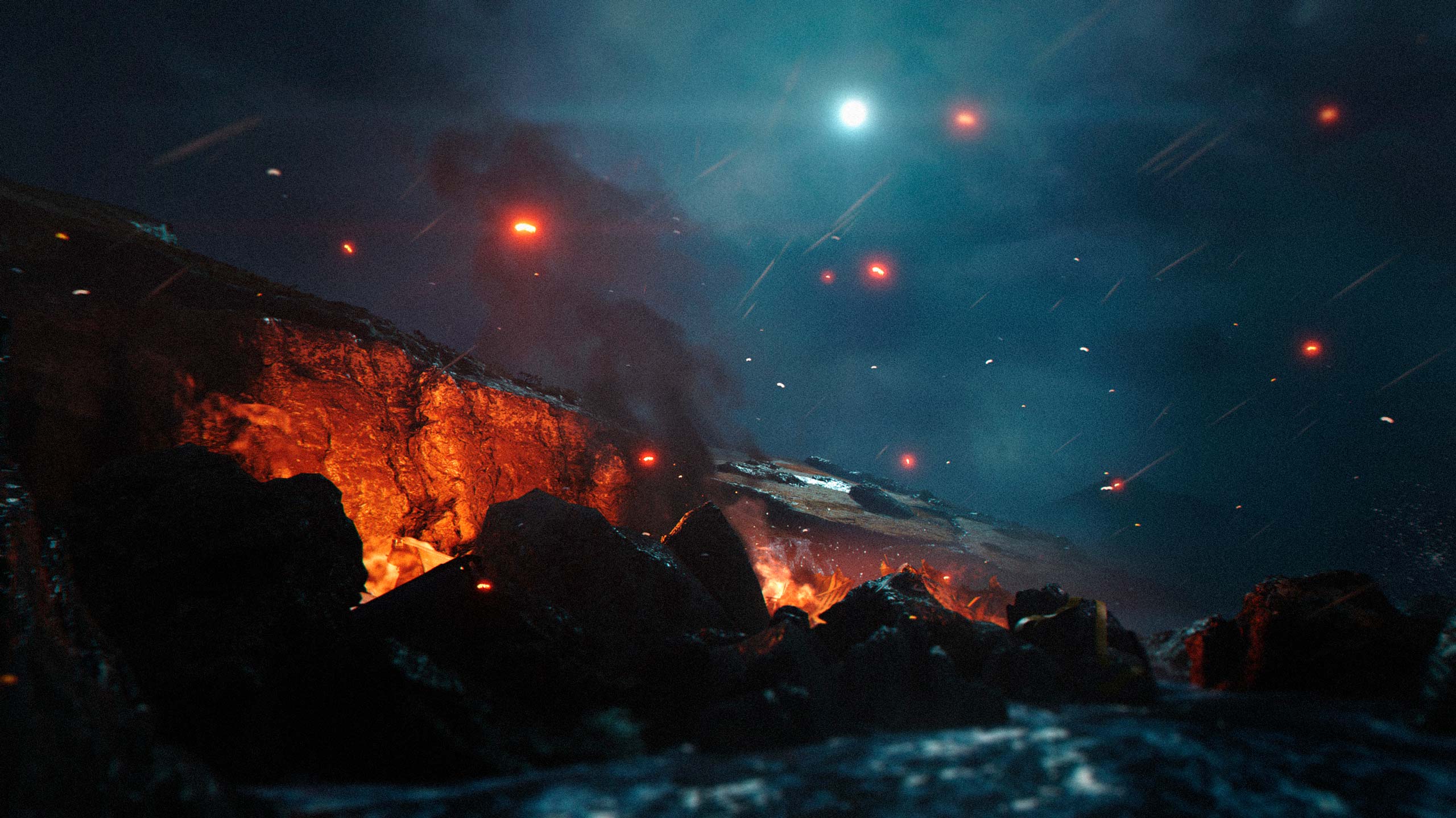 A figure on a dark beach lit by orange embers and distant fires at night in 007 First Light.